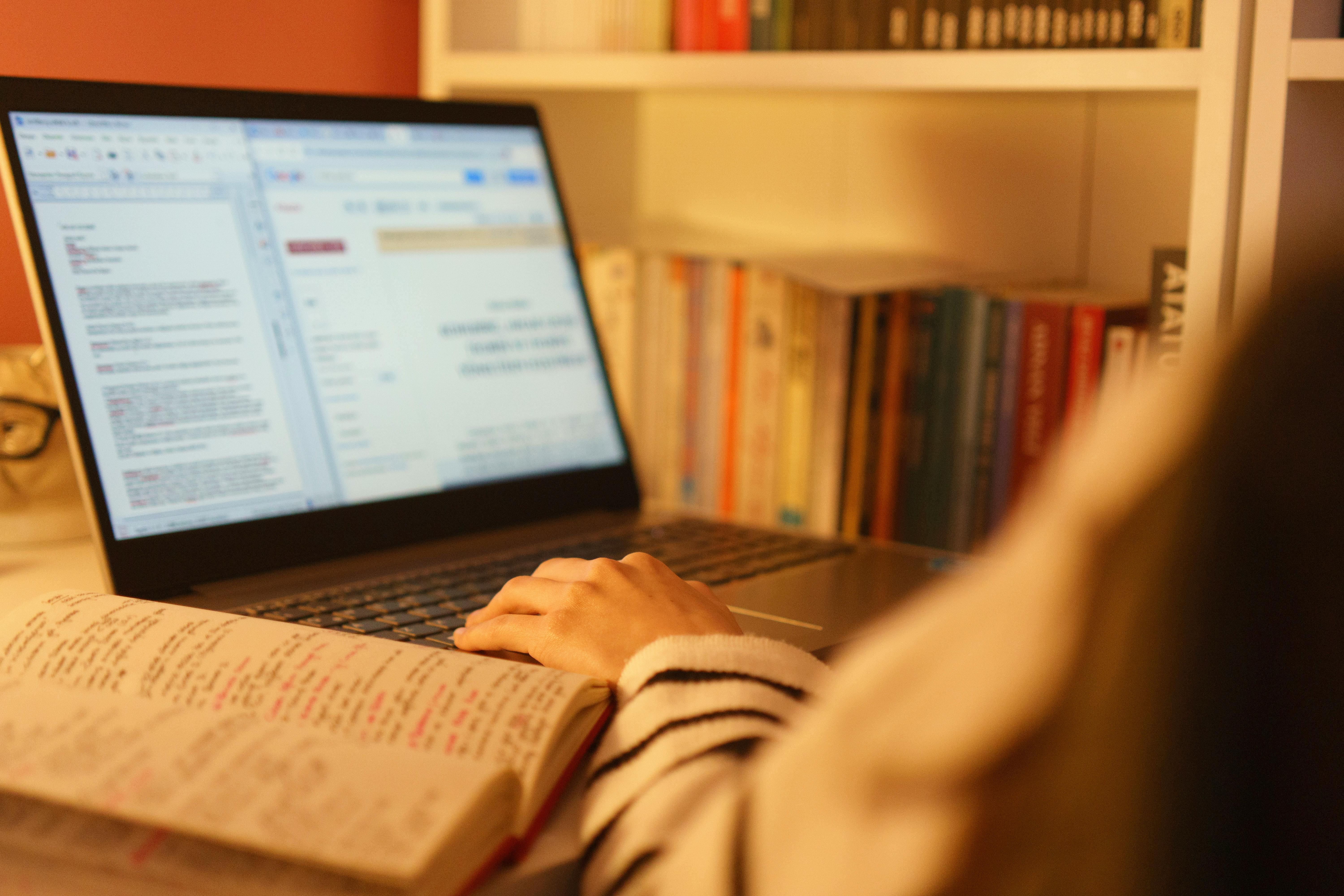 Laptop with technical report and blurred user